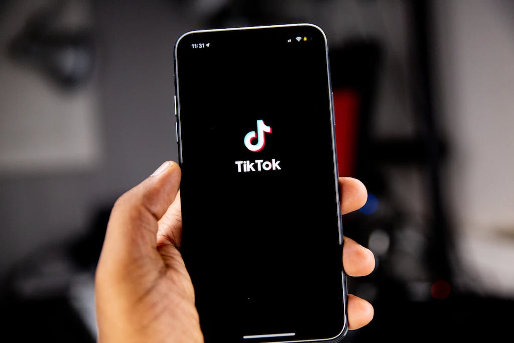 Người cầm chiếc iPhone màu đen đang mở ứng dụng TikTok.